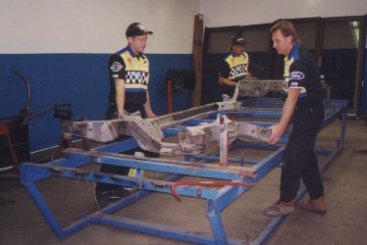 The frame is placed on a jig. The jig holds the frame in place so Glover can cut and modify the frame.